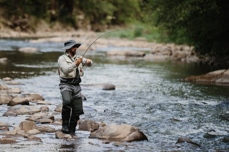 Fisherman casting line into river